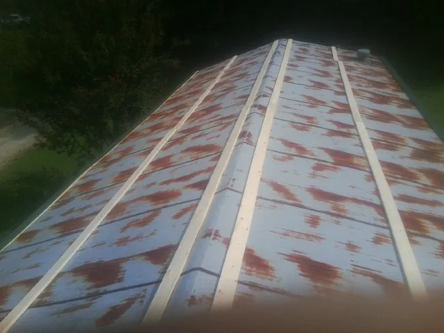Rusted metal roof panels with new wood purlins before replacement — Storm Damage Roof Repair in Spanish Fort by Roofing Brothers