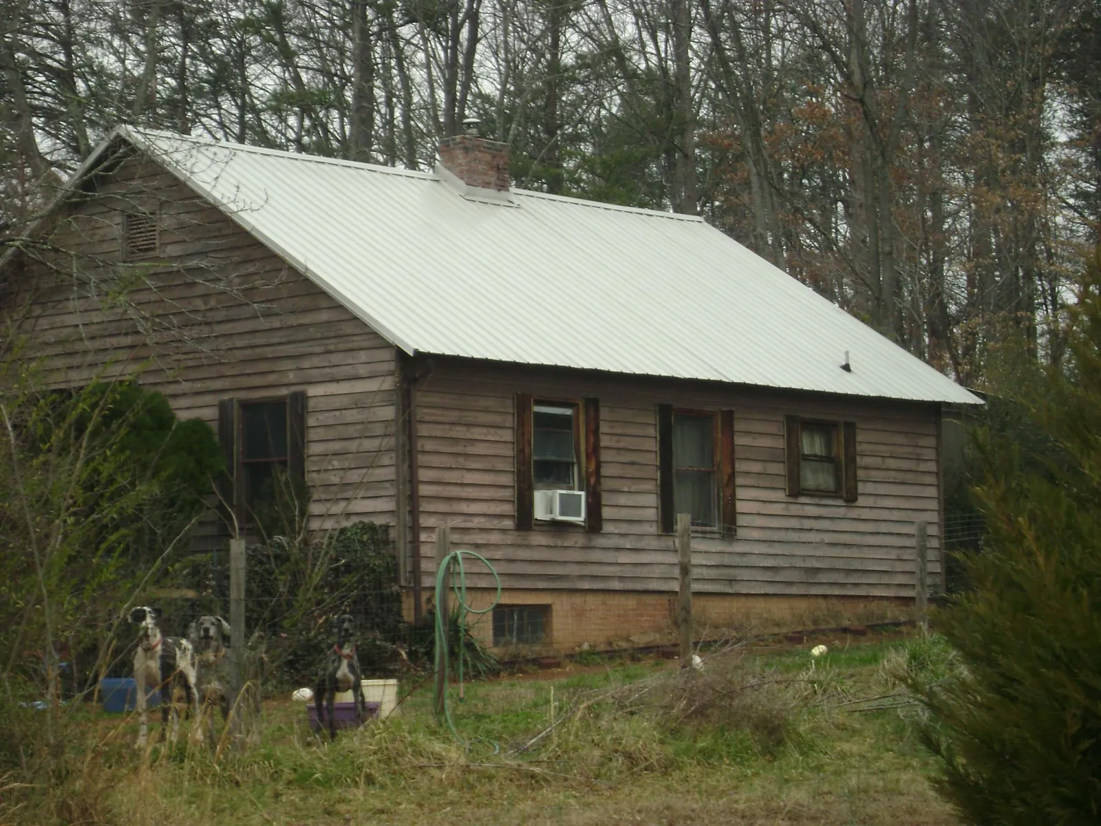White metal roof on an old wood sided farmhouse, from a Metal Roof Installation job in Spanish Fort